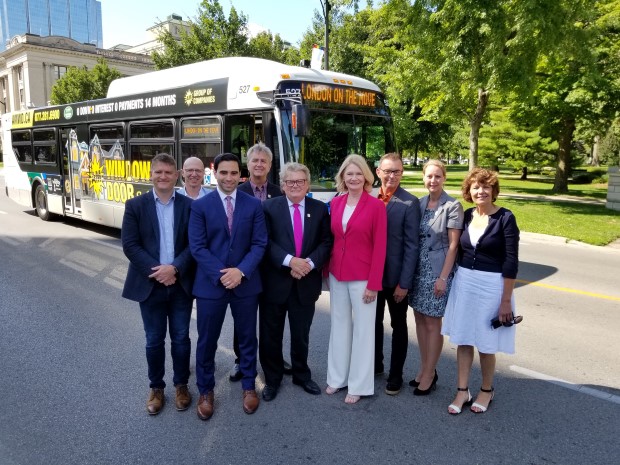 Politicians posing in front of a bus