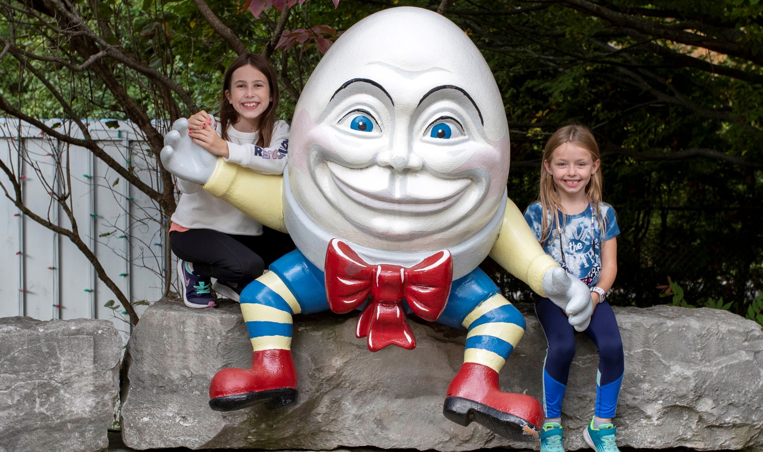 Two girls pose for a picture with Humpty Dumpty