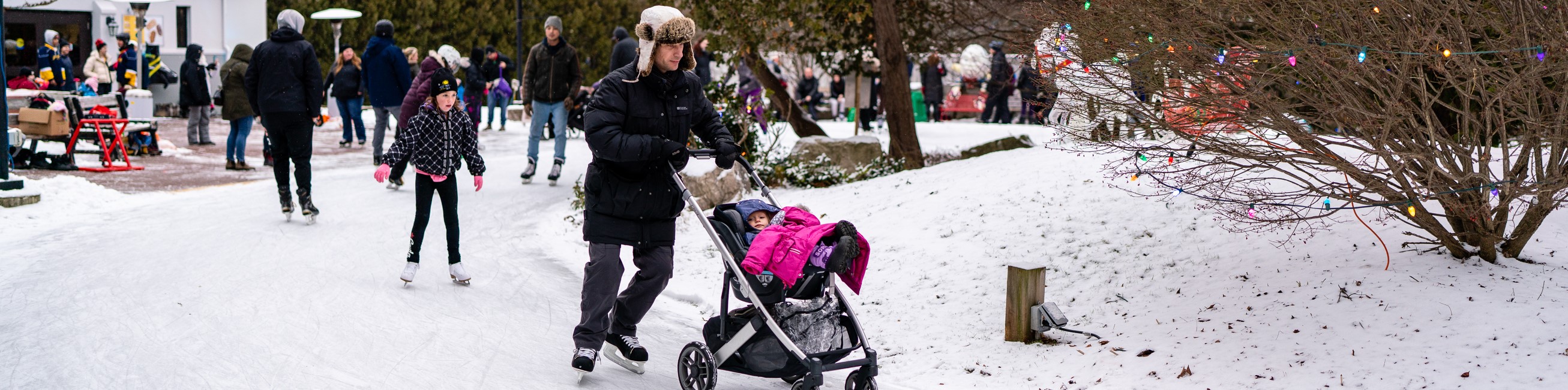 Father pushing daughter in stroller on Storybook Gardens' skate trail