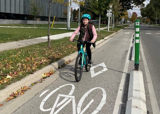 A girl rides her bike in the bike lane on Wavell Street outside East Lions Community Centre.