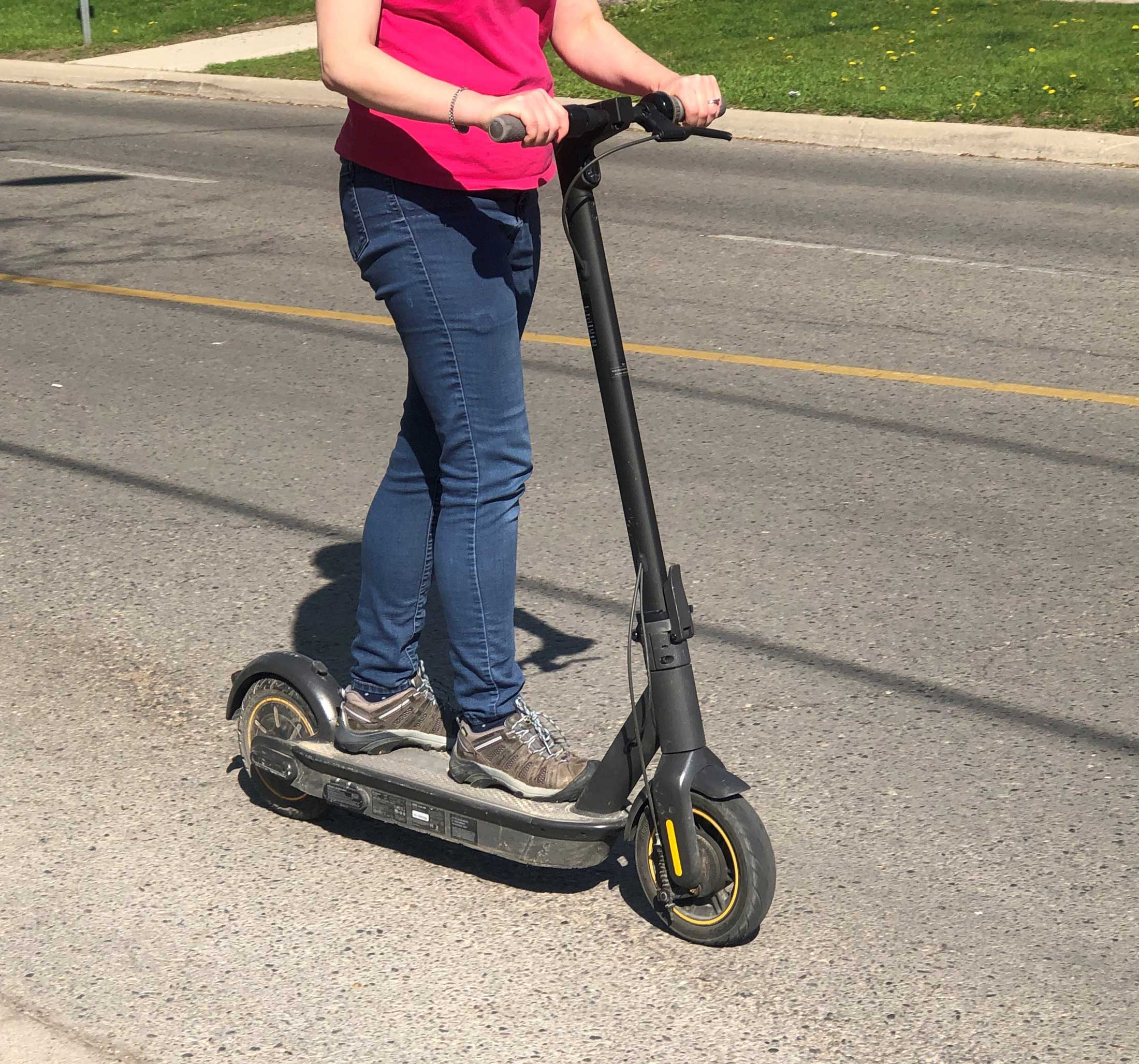 Woman riding a personal electric kick-scooter