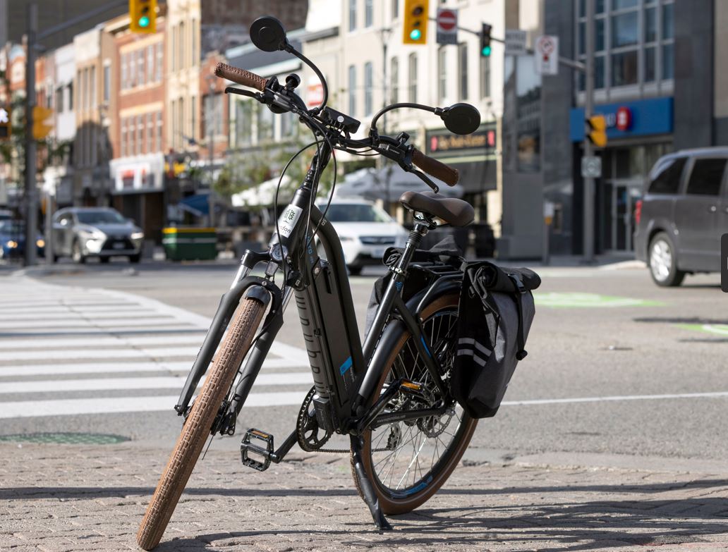 An e-bike parked on a sidewalk downtown. 