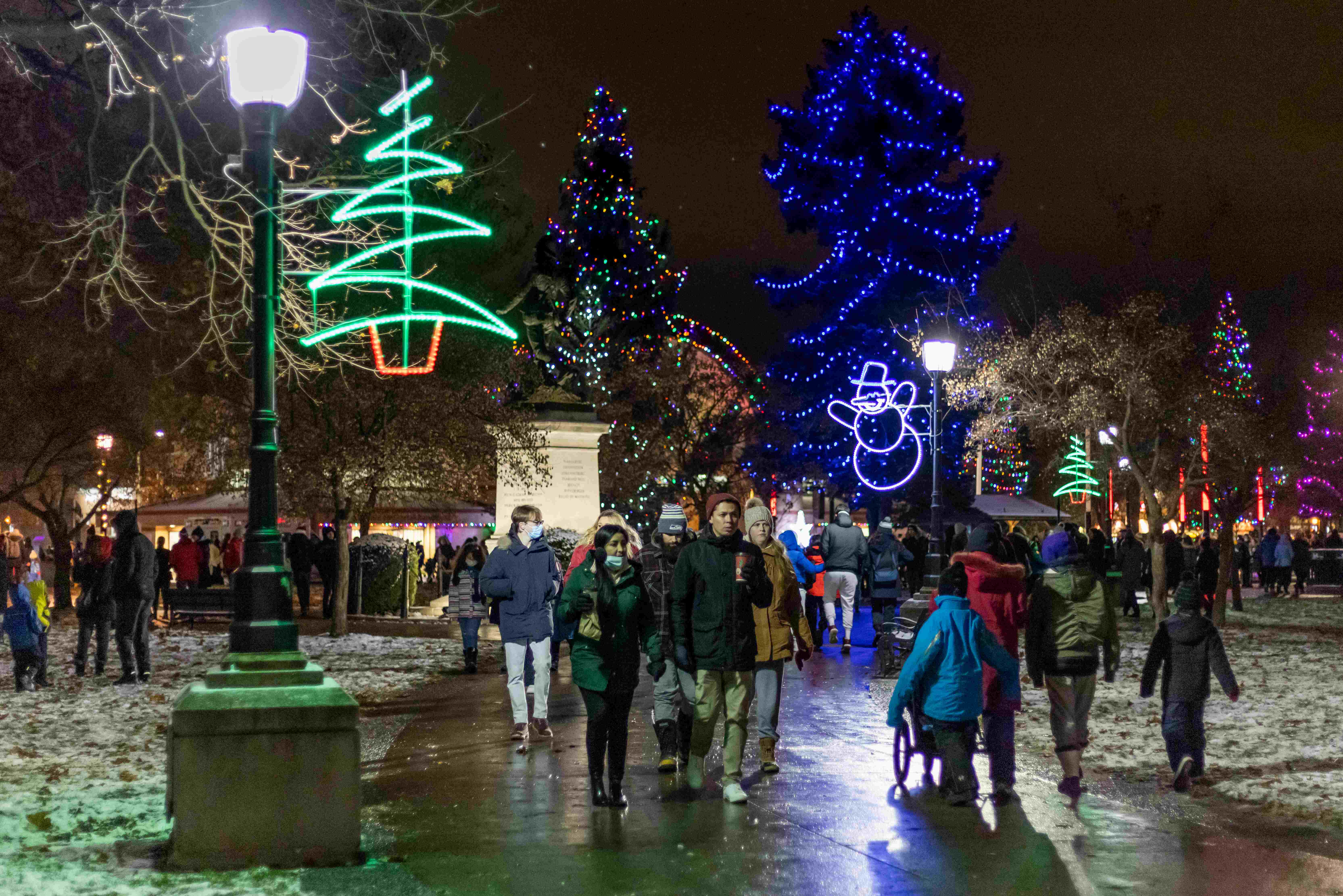 People walking through Victoria Park after Lighting of the Lights as they gaze at the holiday lights. 