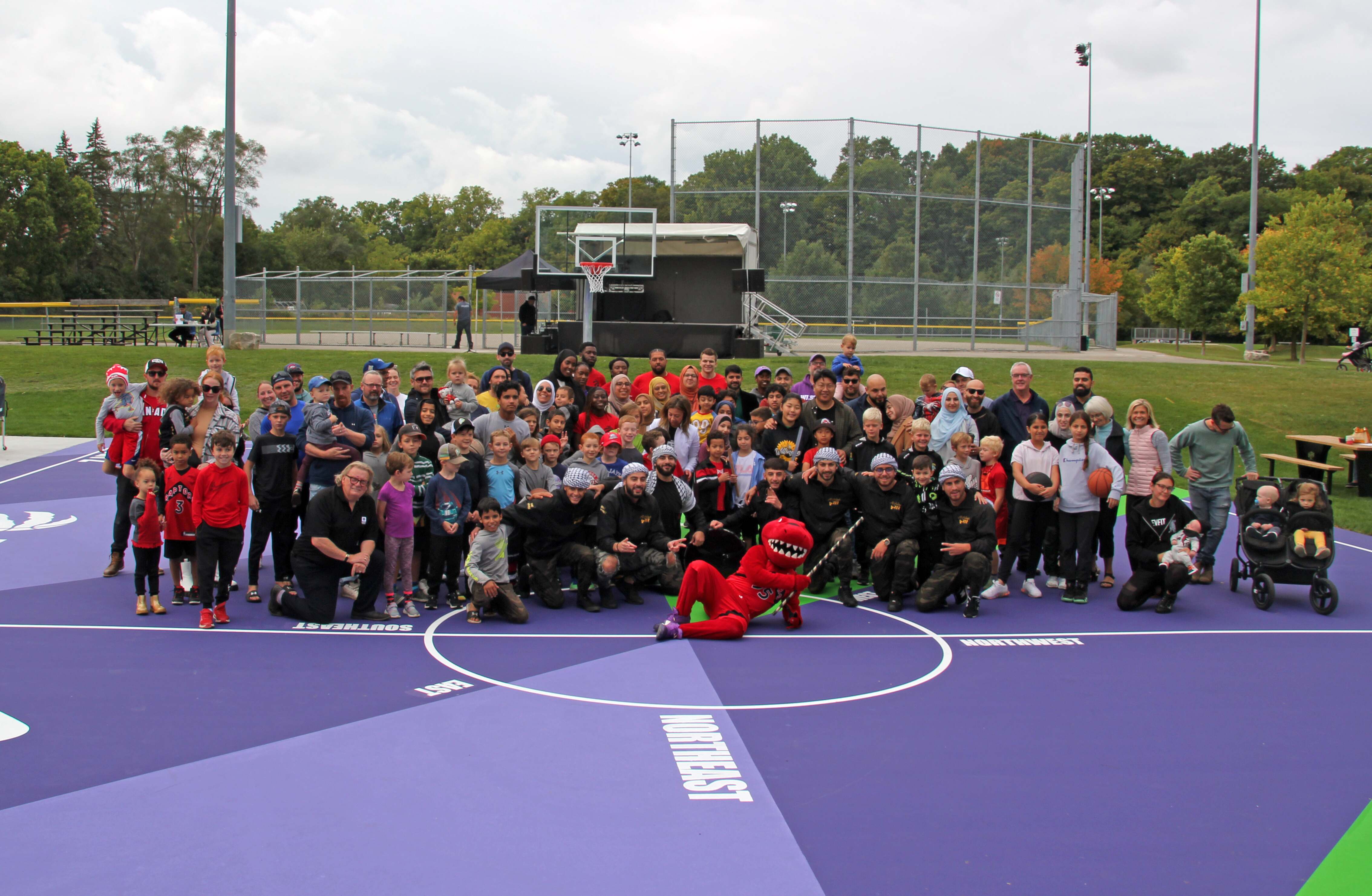 The community poses for a group photo celebrating the reopening of the upgraded basketball courts in West Lions Park