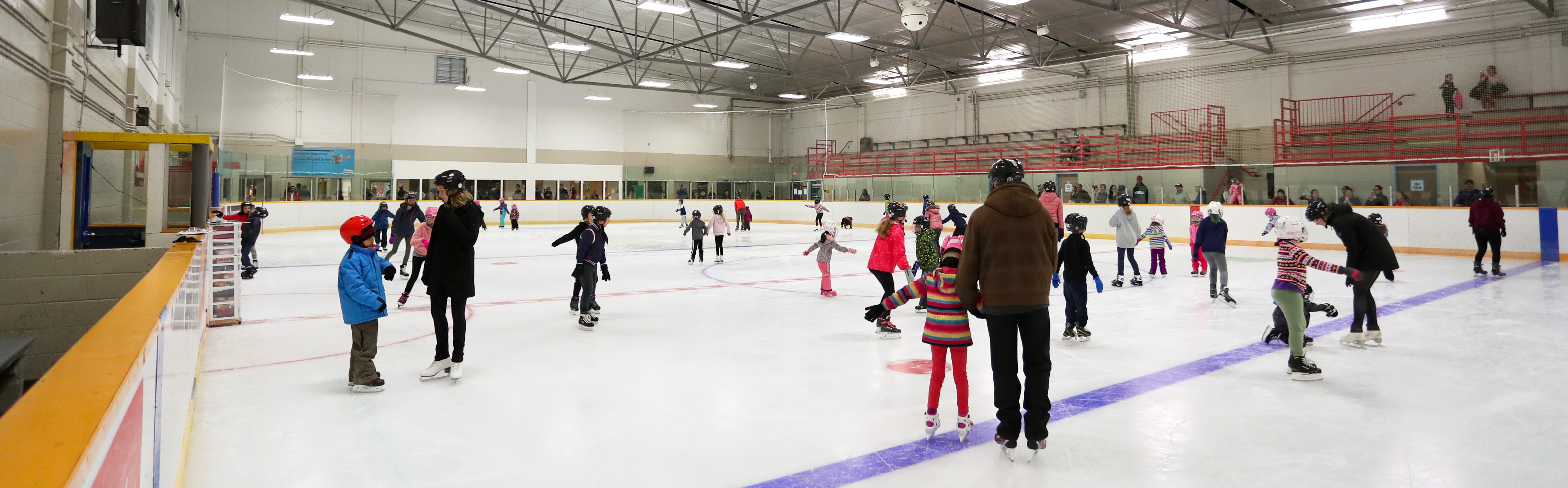 Children and adults skating at one of the City of London's indoor skating rinks. 