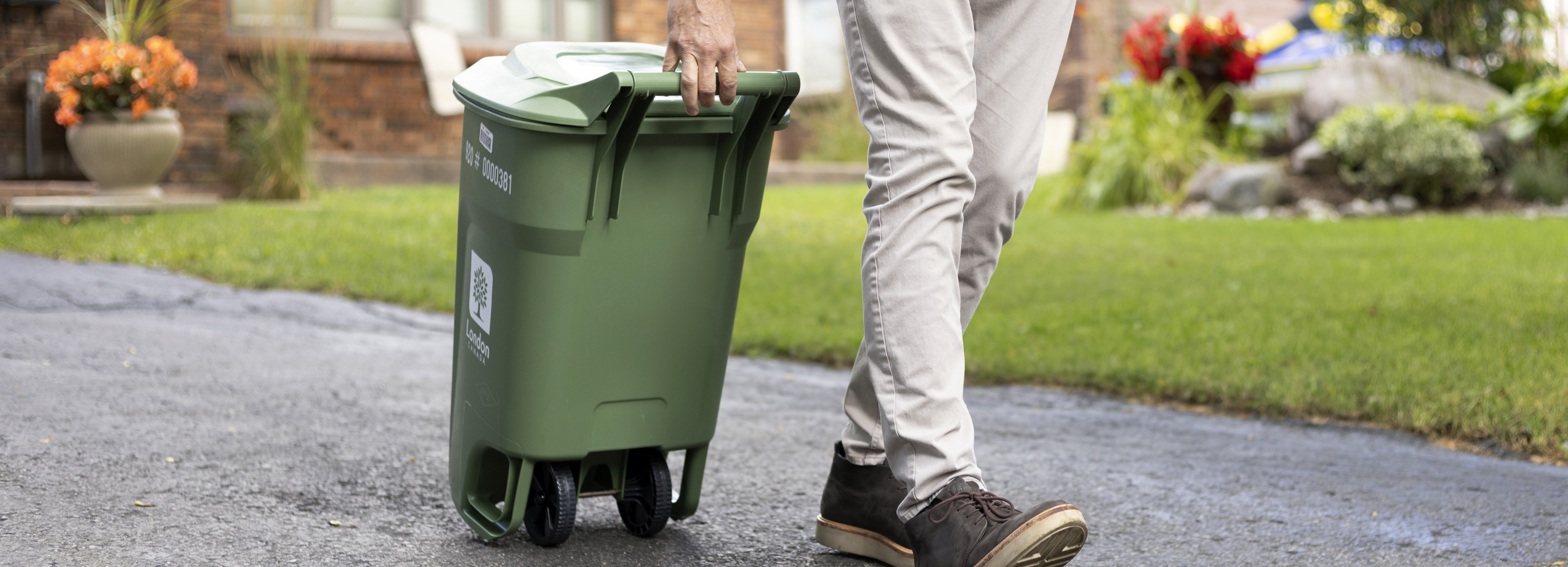 Resident bringing green bin to curb