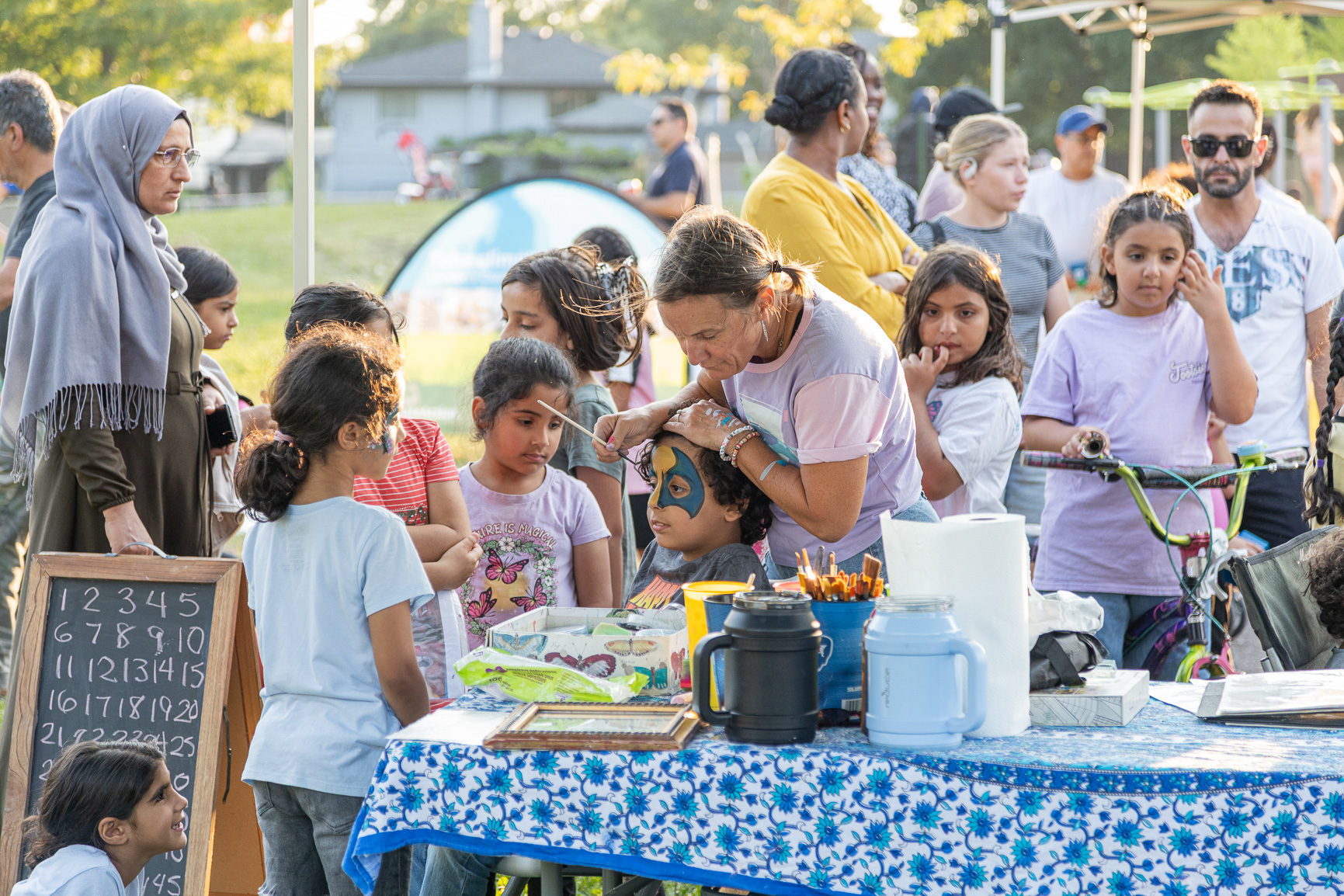Kids getting their face painted in the park