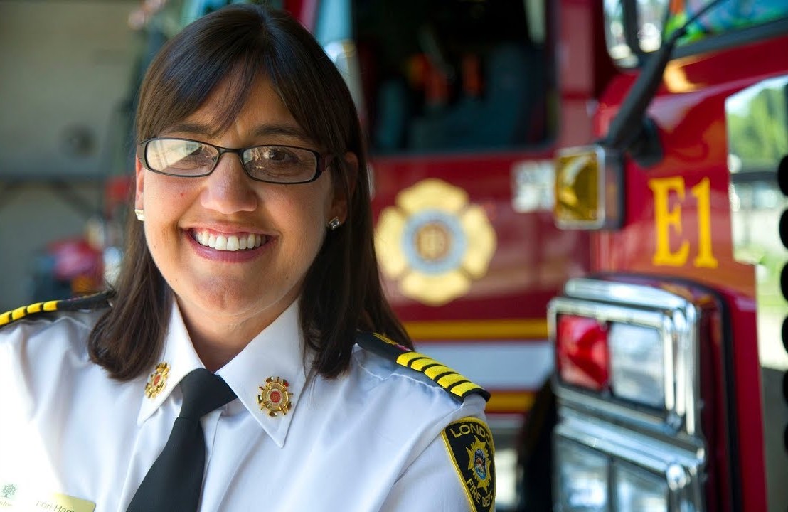 Fire Chief Hamer smiling in front of a firetruck