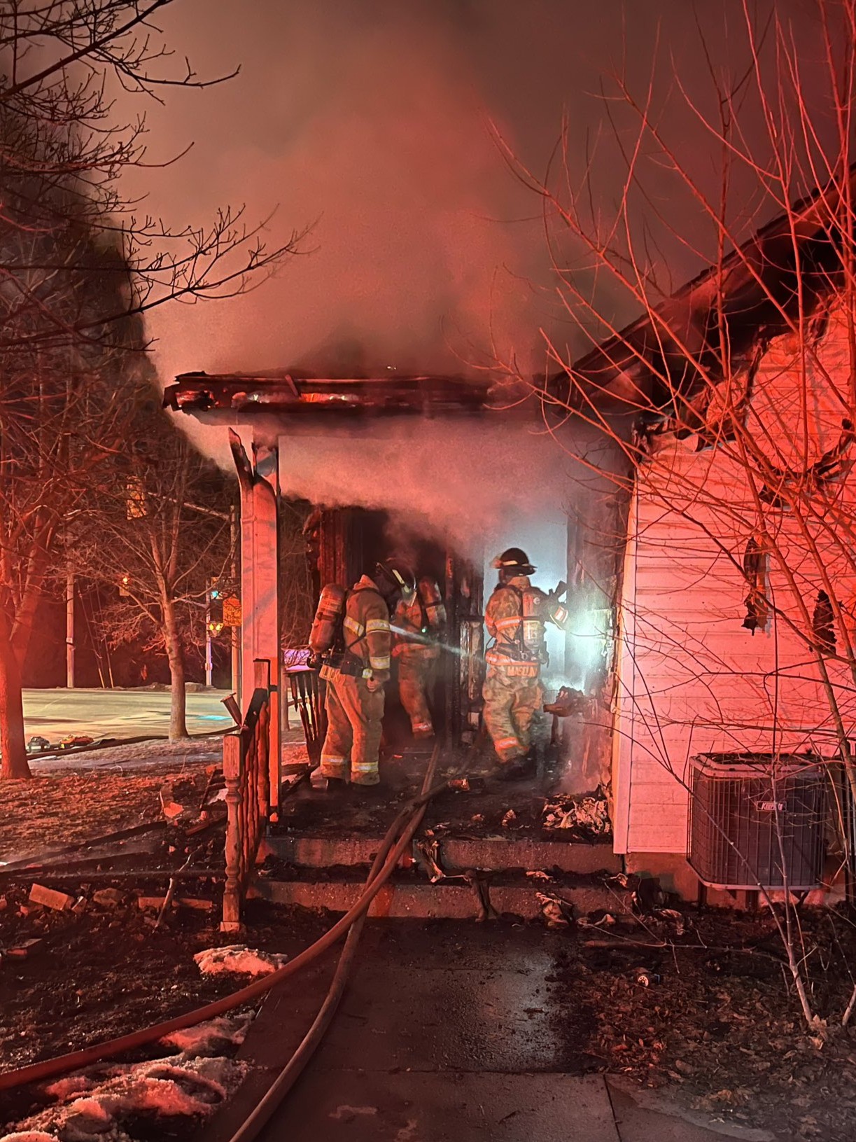 Firefighters putting out a porch fire at night
