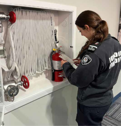 Fire prevention inspector looking at a fire extinguisher