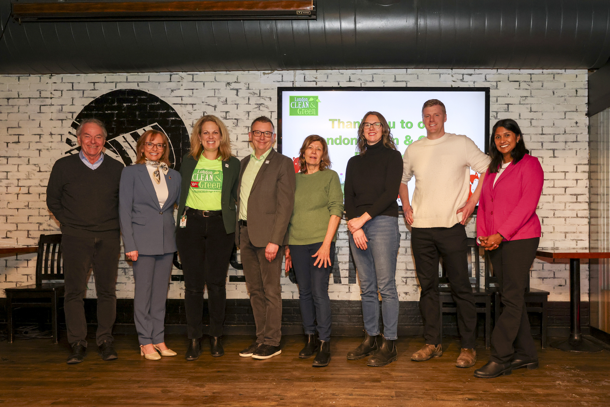 Photo of Graham Henderson (CEO of London Chamber of Commerce), Bev Kobe (President and CEO of Goodwill Industries, Ontario Great Lakes), Shawna Chambers (Director of Climate Change, Environment and Waste Management, City of London), Deputy Mayor Shawn Lewis, Councillor Anna Hopkins, Councillor Skylar Franke, Charlie Smith (Kools Group co-owner), and Councillor Corrine Rahman at the 2026 London Clean and Green launch.