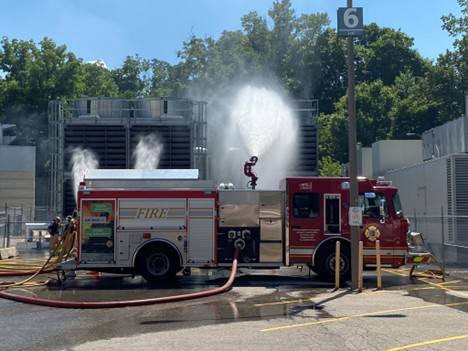 A firetruck is blowing water from its hoses