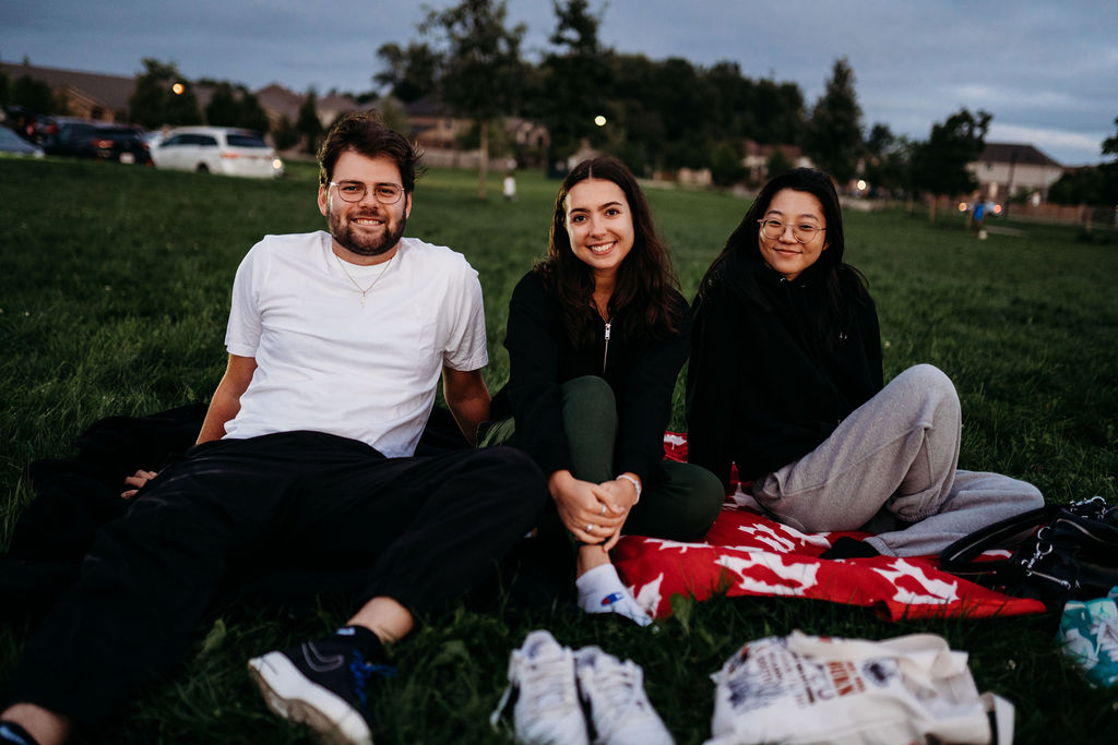 A picture of three people enjoying movie night.