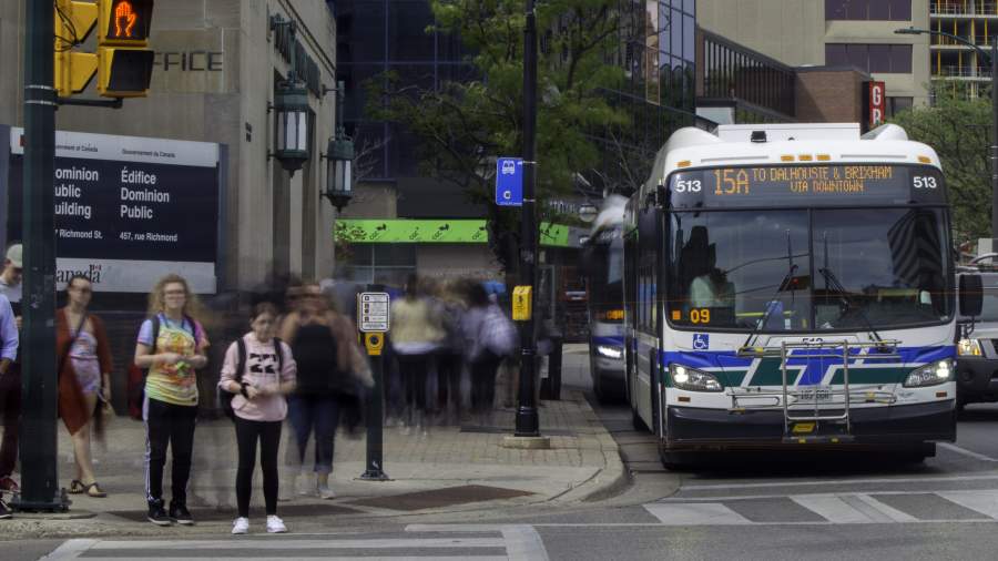 a bus and pedestrians at a downtown intersection