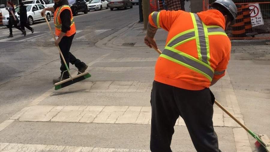 crews sweeping crosswalk