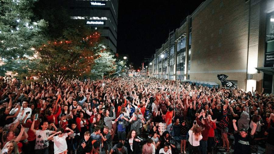 A crowd on Dundas Place watches a Toronto Raptors playoff game