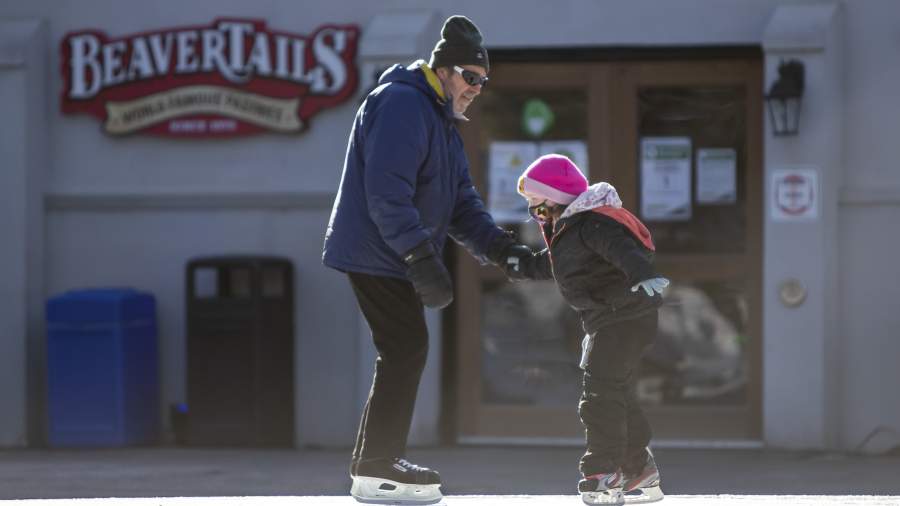 Father and daughter holding hands on the Storybook Gardens' skating trail