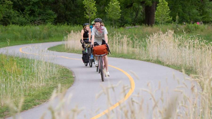 A group of people ride their bikes on the Thames Valley Parkway.