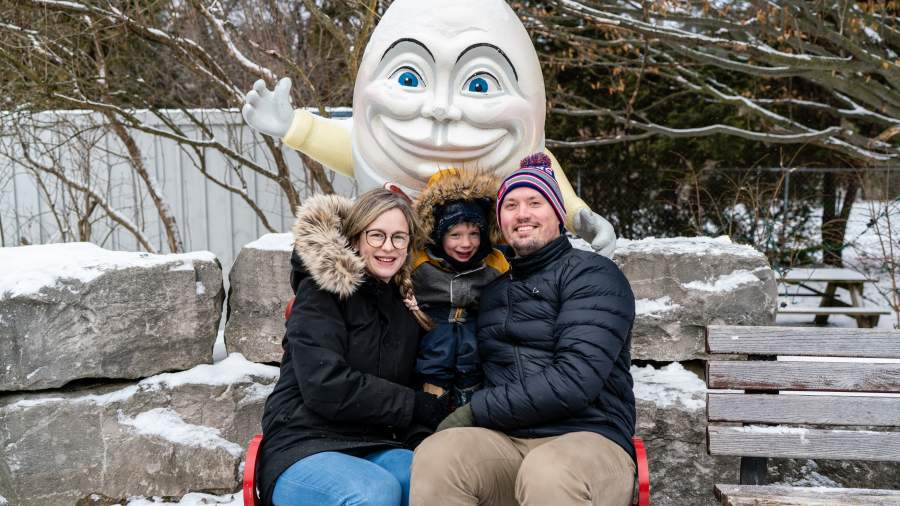 Family sitting in front of Humpty Dumpty during the winter