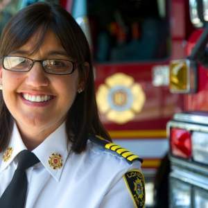 Headshot of Chief Lori Hamer standing beside fire engine